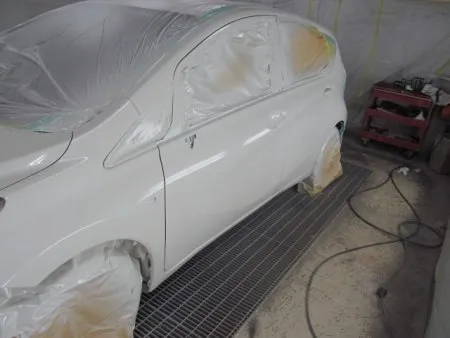 いよいよ塗装に入ります。塗装は塗装専用ブースに手作業をします。<br>塗装する箇所以外は全て専用の覆いでマスキングをして塗料の付着を防ぎます。