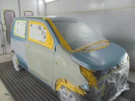 鈑金修理で直せる範囲は、金具を溶接して引っ張りだしたり、ハンマーで叩いたりして、修正していきます。<br>その次に凹凸を埋めるためのパテを塗っていきます。<br>パテを乾燥させ、研磨した後、下地処理剤のサフェーサーを塗布します。<br>同じくサフェーサーを乾燥させ、ペーパーで水研ぎをし、表面を滑らかに仕上げます。<br>写真は塗装面すべてにペーパーで研磨し、周辺をマスキングして下準備が完了したところです。