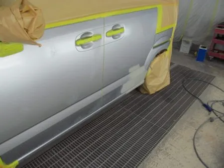 塗装の前にはまず、サフェーサを塗ることから始まります。<br>目の粗いパテの上に直接上塗り塗装をすると、吸い込みがあるので、パテの跡が出てしまいます。<br>それを防ぐため、パテ成形時についたサンドペーパーのキズを埋めるために、下地処理のサフェーサを吹きます。<br>サフェーサ乾燥後最終的な塗装面を出すために細かいサンドペーパーで研磨する足付けを行います。<br>足付けが終わると塗装面の脂分・ワックス分を専用の溶剤できれいに脱脂します。