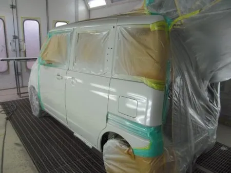 左側面のフロントドアからクオーターパネルにかけて全面を塗装していきます。<br>塗装は専用のブースで行い、ホコリの付着を防ぎます。<br>塗装にあたって、現車の色に合わせて塗料の調合を専門の塗装職人により行い調色を決定します。<br>塗装の前に塗装面の足付け、および脂分・ワックス分を専用の溶剤で綺麗に脱脂してから塗装を実施します。<br>ベースカラー塗装はスプレーガンで数回に分けて、丁寧に塗布をしていきます。<br>カラー塗装のあとはトップコートとしてクリア塗装を行います。<br>クリア塗装をすることで対候性が一段とアップします。<br>充分に加熱乾燥した後、数種類のパフとコンパウンドを使い分けポリッシャーを使用して塗面を磨いて仕上げました。