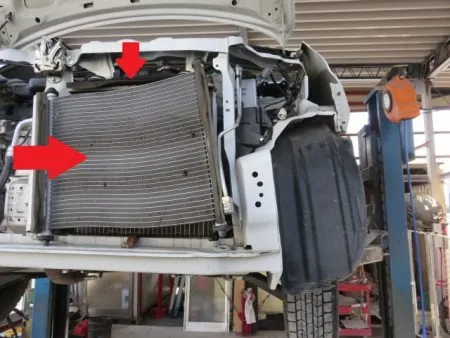 さらに、表側のエアコンコンデンサーが酷く凹んで、裏側にあるラジエターまで押されて破損している状況が見て取れます。<br>ラジエーター及びエアコンコンデンサーは取り換えとなります。