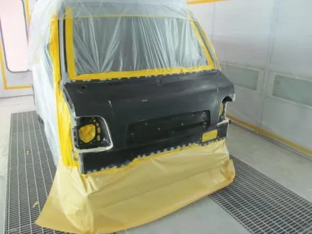 これからフロントパネルの塗装を行っていきますが、塗装は専用のブース(密閉した部屋)にて塗装中のホコリの付着などを防ぎます。<br>また周囲の環境にも配慮しています。<br>さらに塗装中の塗料の飛散による汚れを防止するために、塗装面以外は全て専用のビニールシートやペーパーでマスキングを行ってから塗装を開始します。