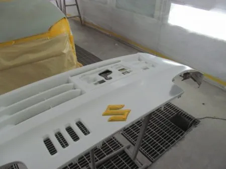 フロントバンパーのキズを修理し、下地処理剤のサフェーサーを塗布したところです。<br>サフェーサーを乾燥させたら、耐水ペーパーを使用して水研ぎをします。<br>バンパー全体も塗装範囲ですので、全体にもペーパーで研磨をしておきます。<br>これも密着をよくする効果があります。