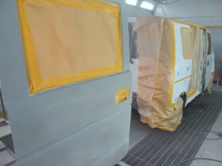 フロントドア及びリアドアは取り外してそれぞれ単体で塗装を行います。<br>単体塗装を完了したフロントドアとリアドアを取り付けて建付けの確認を行います。 <br>車を塗装専用ブース（密閉された部屋）に移動して、塗装中のごみやほこりの付着を防止します。<br>塗装の前に塗装面の足付け、および脂分・ワックス分を専用の溶剤で綺麗に脱脂してから塗装を実施します。<br>まず、塗料がかかってはまずい部分を専用のシートでマスキングを行ってから塗装にかかります。<br>塗装色を当社のベテランの塗装職人が現車の色に合わせて塗料の調合を行って色合わせをして塗装色を決めます。